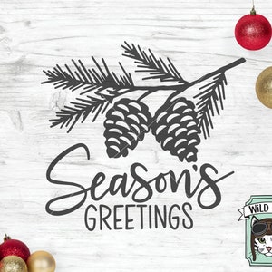 May include: Black and white illustration of a pine branch with two pine cones. The text "Season's Greetings" is written in a decorative font below the branch. A small cartoon image of a cat wearing aviator goggles is in the lower right corner with the text "Wild Pilot" above it.