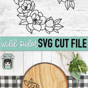 May include: Black and white floral design with five flowers and leaves. The design is shown on a wooden tray with a black metal rim. The text "Wild Pilot SVG CUT FILE" is shown above the tray.