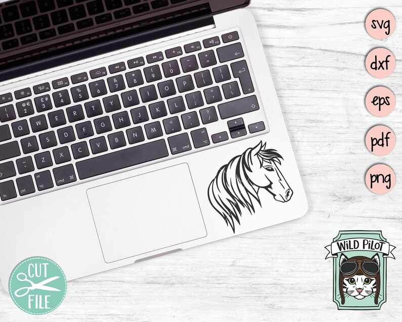 May include: A black and white line art illustration of a horse's head. The image is on a laptop screen. The laptop is on a white wooden surface. There are five circles with text in them: svg, dxf, eps, pdf, and png. Below the circles is a cartoon image of a cat wearing aviator goggles with the text "WILD PILOT" above the cat.