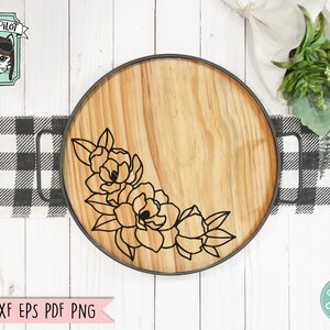 May include: A wooden serving tray with a black metal rim and a floral design. The design features a cluster of stylized flowers in the lower left corner of the tray.