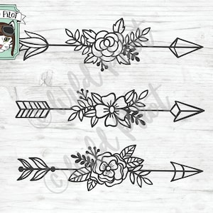 May include: Three black and white floral arrow designs with a geometric arrowhead. The arrows are layered on a woodgrain background.