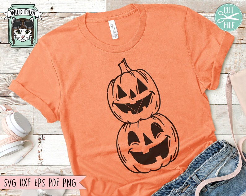 May include: Orange t-shirt with a black graphic of two stacked jack-o'-lantern pumpkins with smiling faces.