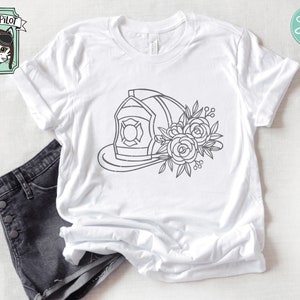 May include: A white t-shirt with a black line drawing of a firefighter's helmet with flowers on the side.