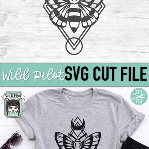 May include: A black and white digital design featuring a moth with geometric shapes and a crescent moon. The design is on a grey t-shirt with a white background. The text "Wild Pilot SVG CUT FILE" is at the top of the image.