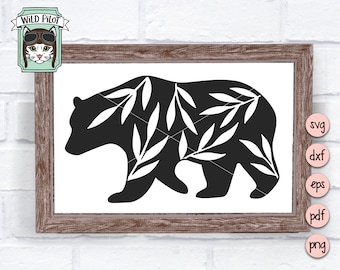 May include: Black bear silhouette with white leaf design, framed in a rustic brown wooden frame. The image includes the text "Wild Pilot" with a cat wearing aviator goggles. Digital file formats: SVG, DXF, EPS, PDF, PNG.