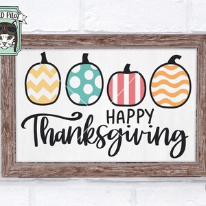 May include: A wooden sign with a white background and the text "Happy Thanksgiving" in black cursive font. Four pumpkins with different patterns are arranged across the top of the sign. The pumpkins are yellow and white chevron, teal with white polka dots, pink and white stripes, and orange and white waves.