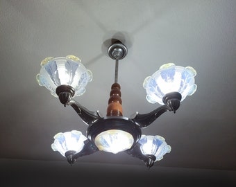 May include: A silver and wood chandelier with five frosted glass shades. The shades are shaped like flowers with a blue and white design.