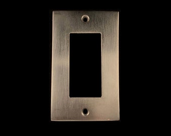 May include: A brushed nickel wall plate with a rectangular opening for a light switch or outlet.