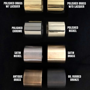 Puede incluir: Primer plano de ocho cilindros met&aacute;licos en diferentes acabados, incluyendo lat&oacute;n pulido con y sin laca, cromo pulido, n&iacute;quel pulido, n&iacute;quel satinado, lat&oacute;n satinado, lat&oacute;n antiguo y bronce frotado al aceite.