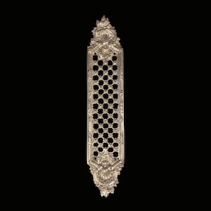 May include: Ornate, silver-colored decorative vent cover with a rectangular shape. The cover features a detailed floral and scroll design around the edges and a pattern of small, circular holes in the center. The background is black.