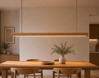 May include: A linear wooden pendant light fixture suspended by two thin cords, featuring a long horizontal beam with an integrated LED light strip facing downward, providing illumination over a wooden dining table and chairs.