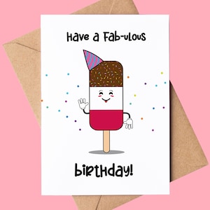 Puede incluir: Una tarjeta de felicitación blanca con un personaje de paleta de dibujos animados con un gorro de fiesta. La paleta tiene una parte superior cubierta de chocolate, un centro blanco y una base roja. La tarjeta dice "Have a Fab-ulous Birthday!" con confeti.