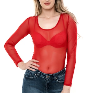 May include: A woman wearing a sheer red long-sleeve top and blue jeans. The top has a scoop neckline and is paired with a red bra. The jeans are a dark wash denim.