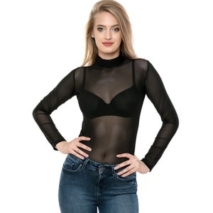Op de afbeelding: Een zwart doorschijnend longsleeve shirt met een mock neck en een zwarte bh eronder. Het shirt wordt gecombineerd met een blauwe jeans.