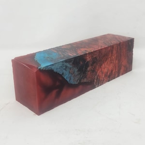 May include: A rectangular block of wood with a red and blue resin pour. The resin is swirled and has a marbled effect.
