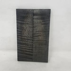 May include: Two pieces of dark wood with a black and brown grain pattern. The wood is cut into rectangular shapes and is ready for woodworking projects.