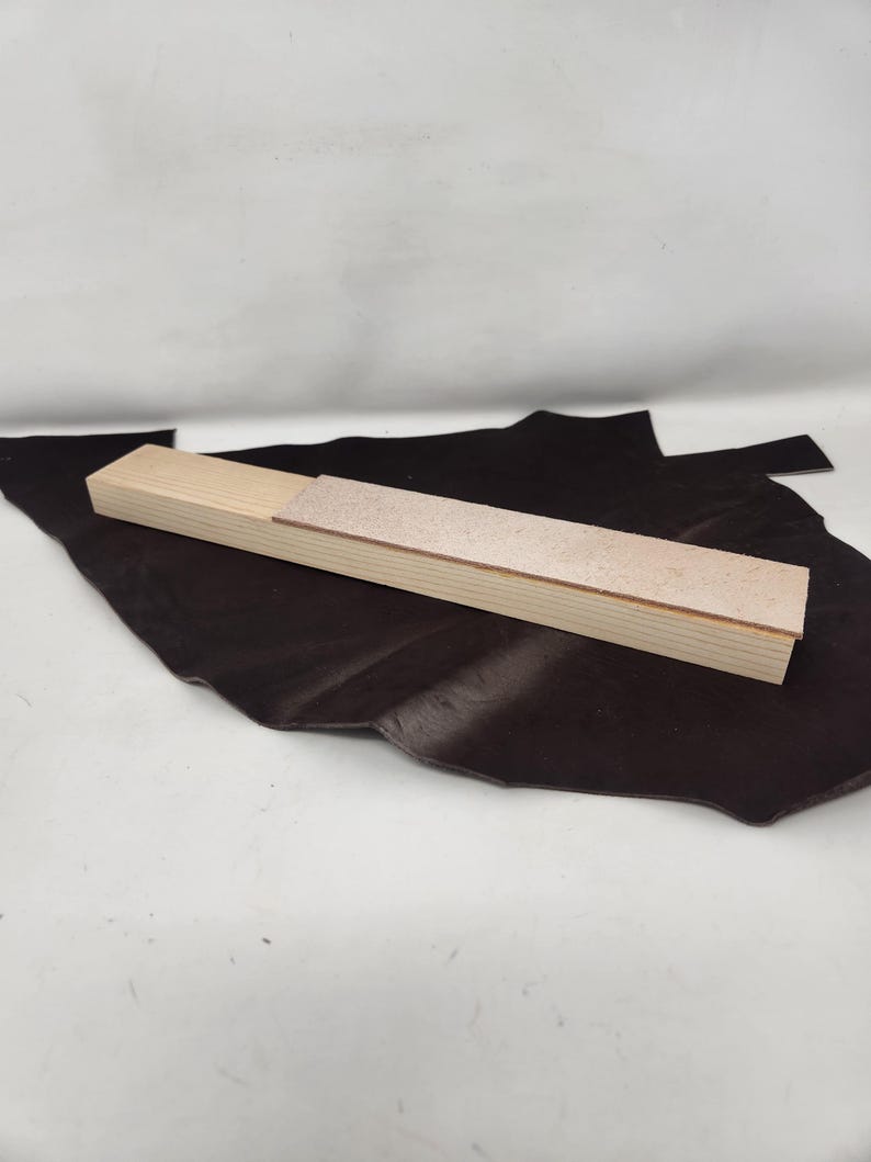 May include: A wooden sanding block with a light brown sanding surface. The block is open and the sanding surface is visible.