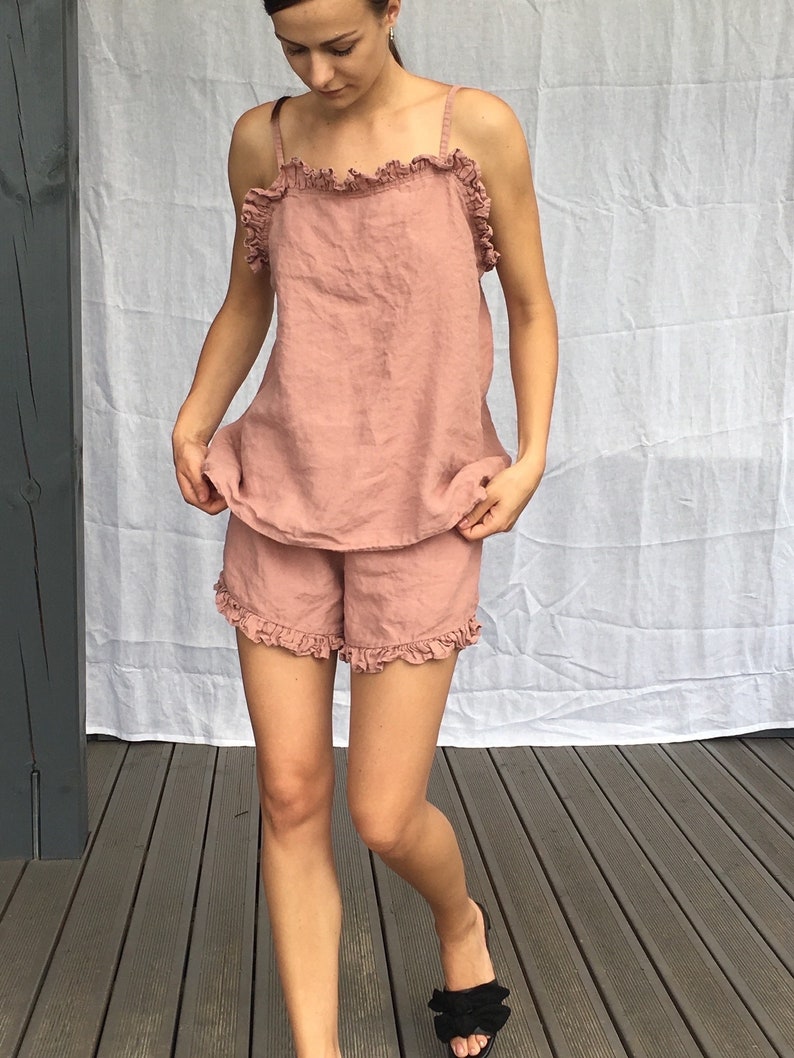 Puede incluir: Un conjunto de pijama de lino rosa polvoriento con una parte superior con volantes y pantalones cortos. El conjunto est&aacute; hecho de una tela suave y ligera, perfecto para dormir o relajarse en casa.