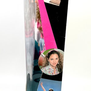 May include: A box for a Tiger Electronics game called "Saved by the Bell". The box is black with a pink stripe and features images of the characters from the show. The text on the box reads "Tiger Electronics, Inc. 980 Woodland Parkway Vernon Hills, Illinois 60061 U.S.A. &copy; 1992 Tiger Electronics, Inc. SAVED BY THE BELL is a trademark of National Broadcasting Company, Inc. Manufactured by Tiger Electronics, Inc. All rights reserved."