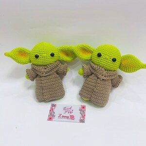 May include: Two crocheted green and brown plush toys with large ears and black eyes. The toys are sitting on a white surface with a small card that says "Thank you! Z.Inky".