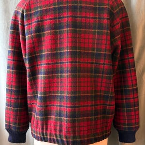 Puede incluir: Chaqueta a cuadros roja, verde y azul marino con cuello alto y pu&ntilde;os y dobladillo de canal&eacute; azul marino. La chaqueta se exhibe en un maniqu&iacute;.