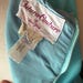 May include: A light blue garment featuring a white interior label with the text Futura Couture of New York in dark pink script. A smaller white tag below displays the text Made in U.S.A. and includes a blue circular logo with text.