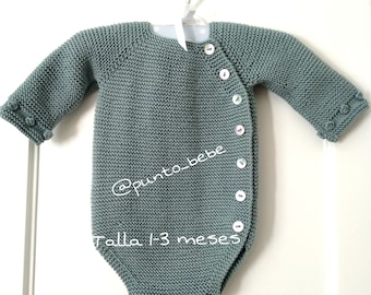 May include: A light blue knitted baby onesie with white buttons and the text "@punto_bebe Talla 1-3 meses".
