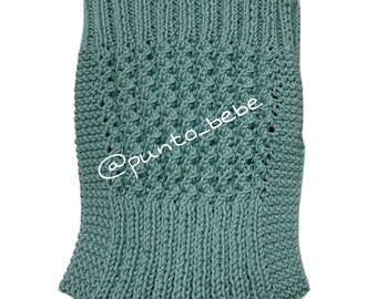 May include: A teal blue knitted baby blanket with a diamond pattern. The blanket has a textured knit and is made with soft yarn. The blanket is perfect for a baby shower gift or for a new baby.
