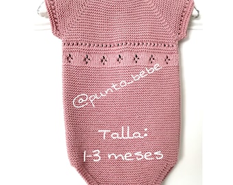 May include: A pink knitted baby onesie with short sleeves and a delicate lace pattern around the neckline. The onesie is labeled "Talla: 1-3 meses" which translates to "Size: 1-3 months".
