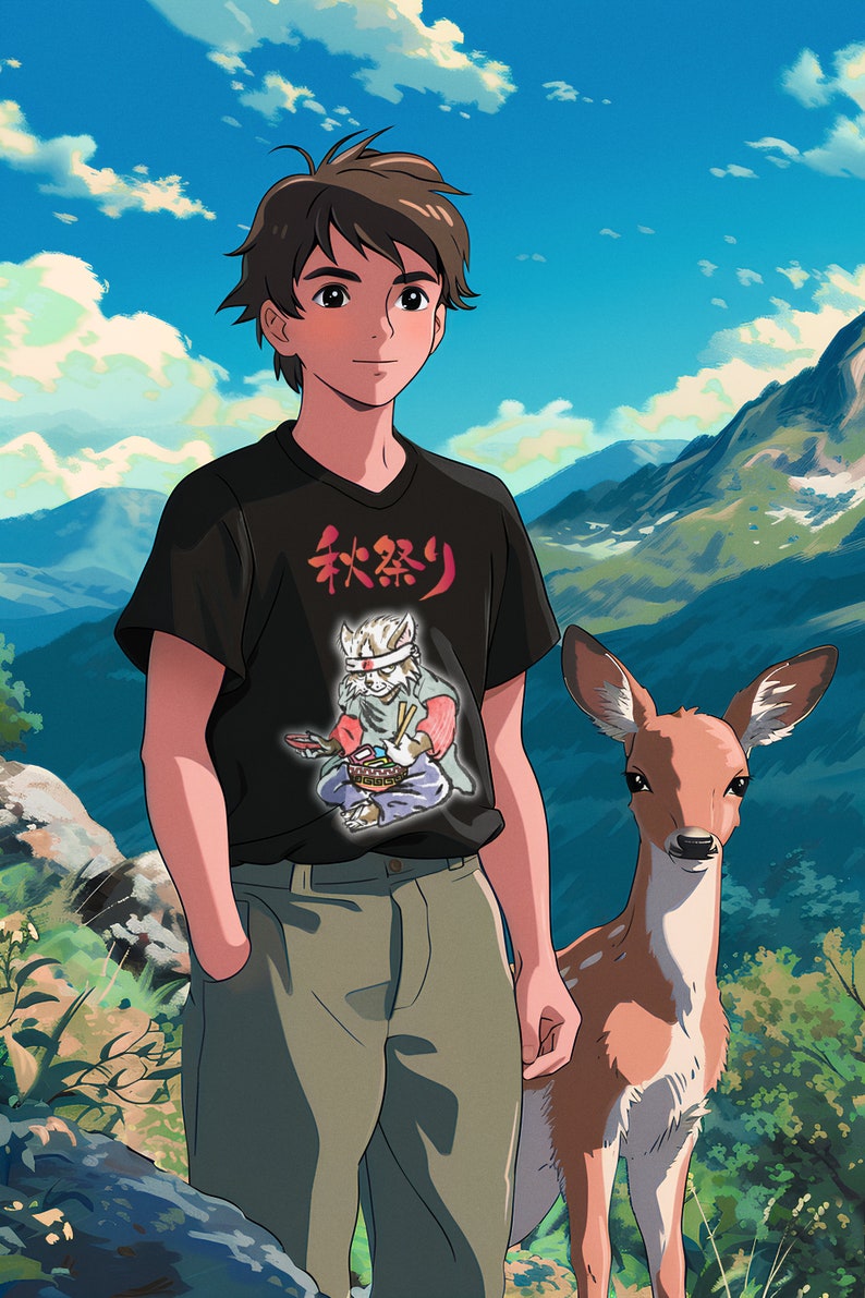 Puede incluir: Un joven con una camiseta negra con un dise&ntilde;o de caracteres japoneses y un ciervo de pie a su lado. La camiseta presenta un personaje de dibujos animados sosteniendo palillos y un taz&oacute;n de comida. El fondo es un cielo azul con nubes blancas y monta&ntilde;as verdes.