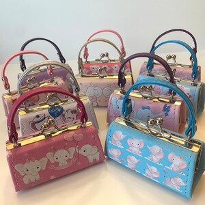 May include: A collection of small, colourful purses with a top handle and a clasp closure. Each purse features a different design of elephants with various patterns and colours.