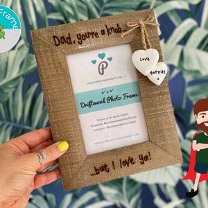 May include: A rustic brown driftwood photo frame with the text "Dad, you're a knob... but I love ya!"  The frame is 15.2 cm by 10.2 cm and has two white ceramic hearts hanging from it with the text "Love" and "Harriet".