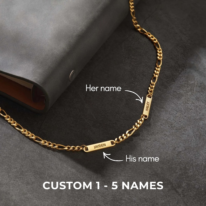 Puede incluir: Un collar de cadena figaro de color dorado con dos placas rectangulares con nombres. Una placa dice "Jayden" y la otra "Hailey". Los textos "Her name" y "His name" est&aacute;n junto a las placas con nombres. El texto "CUSTOM 1 - 5 NAMES" est&aacute; en la parte inferior.