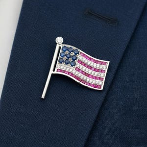 Broche de solapa con bandera estadounidense presidencial de diamantes, rubíes y zafiros en oro blanco de 14 quilates.