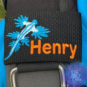 May include: Black fabric tag with a blue and white embroidered sea slug and the name Henry in orange embroidery.