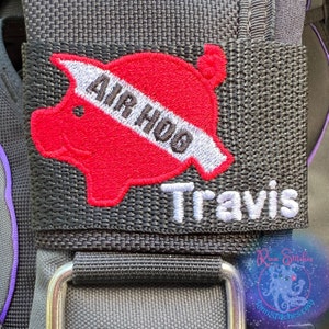 Può includere: Toppa in tessuto nero con un maiale ricamato in rosso e bianco con il testo "Air Hog" e il nome "Travis" ricamato in bianco.