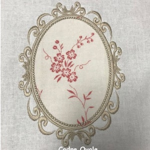 Peut inclure: Un tissu beige avec un cadre ovale brodé en fil doré. À l'intérieur du cadre, un motif floral rouge. Le texte "Cadre Ovale Les broderies de Sylviane" est sous le cadre.