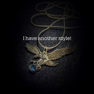 May include: A silver eagle pendant necklace with a blue gemstone. The necklace is on a black background. "I have another style!" is written in white text.