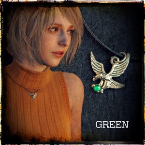 May include: A silver eagle pendant necklace with a green gemstone. The pendant is on a black cord. The word "GREEN" is written in white letters on a black background.