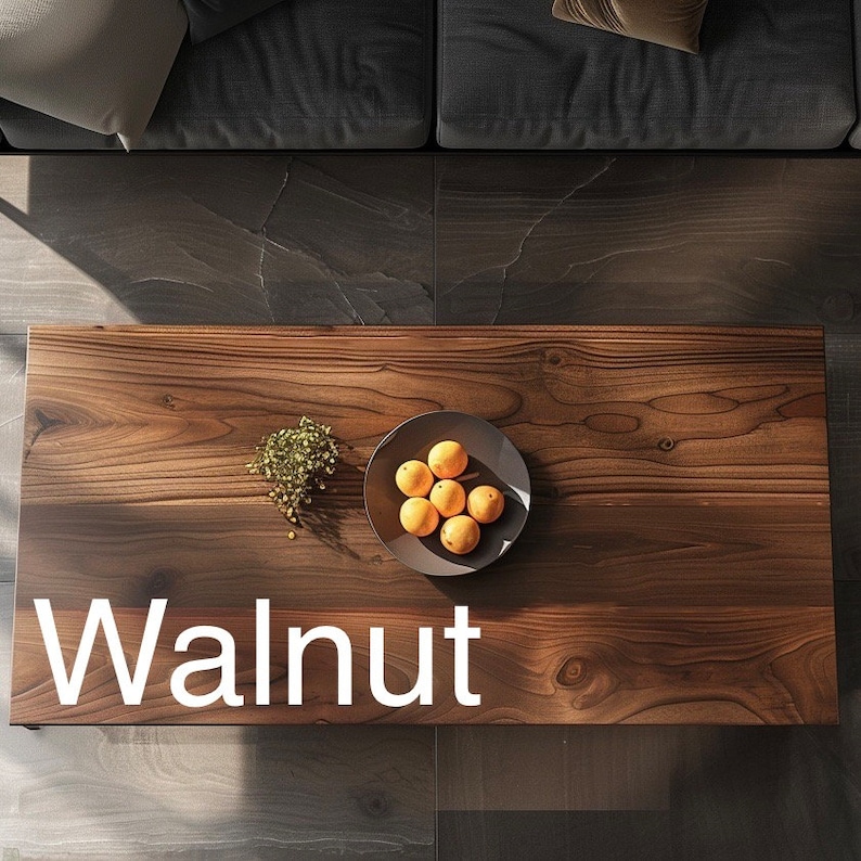May include: A dark brown wooden coffee table with a bowl of oranges and a small plant on top. The table is labeled "Walnut".