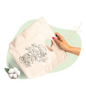 May include: A white canvas tote bag with black and white illustrations of sandwiches and the text "Lunch Time". The bag has a cut-out handle.