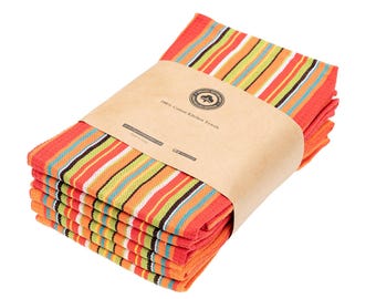 Op de afbeelding: Een stapel keukendoeken met een levendig streeppatroon in oranje, groen, wit en blauw. De doeken zijn samengebonden met een bruine papieren band met het opschrift 100% Cotton Kitchen Towels, een rond logo en de tekst Made in India.