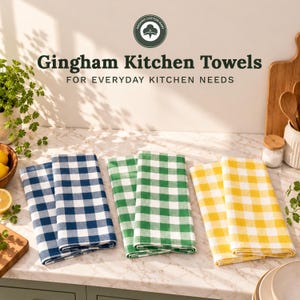 May include: Three sets of folded kitchen towels featuring a gingham check pattern in blue, green, and yellow. The text "Gingham Kitchen Towels" and "FOR EVERYDAY KITCHEN NEEDS" appears above the towels, along with an Organic Cotton Mart logo.