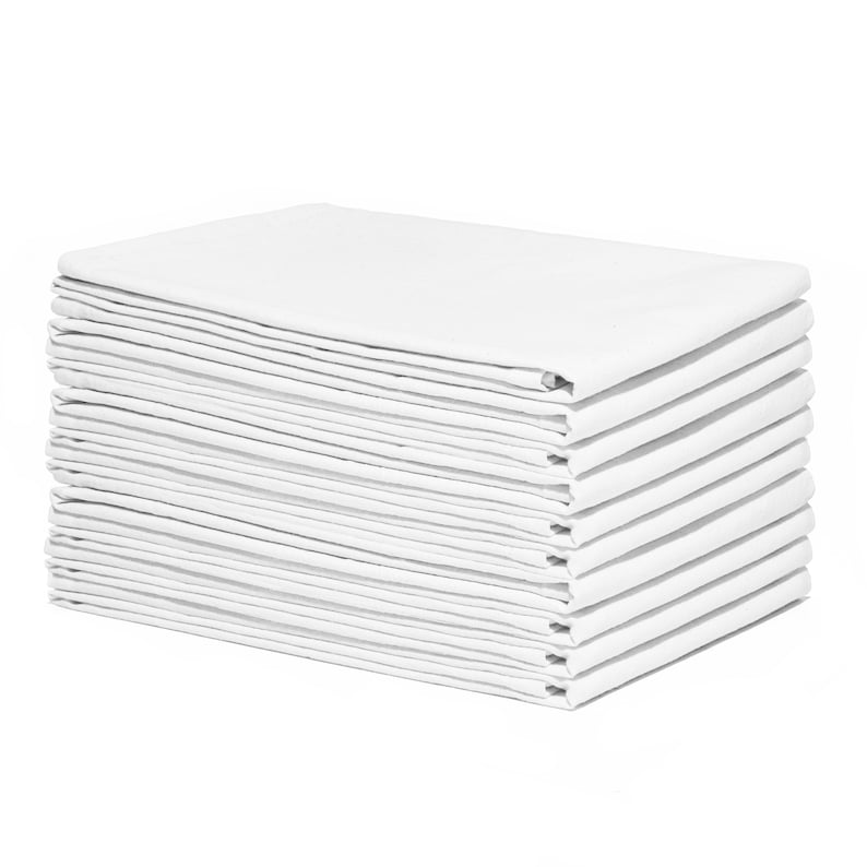 Op de afbeelding: Een stapel gevouwen witte servetten. De servetten zijn netjes gerangschikt in een rechthoekige vorm, met zichtbare vouwen en randen. De helderwitte kleur suggereert een schone en frisse uitstraling, geschikt voor diners of evenementen.