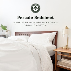 May include: A white percale bedsheet set on a dark wood bed frame. The text reads: Organic Cotton Mart, Percale Bedsheet, Made with 100% GOTS-certified organic cotton. A lamp sits on a wooden side table next to the bed with white bedding.