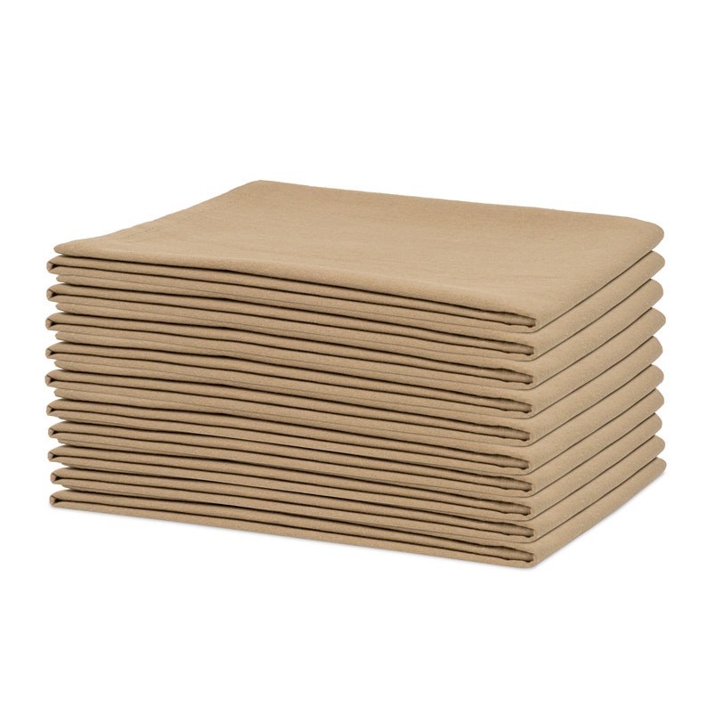 Op de afbeelding: Een stapel gevouwen, vierkante, beige stoffen servetten. De servetten zijn netjes gerangschikt in een rechthoekige vorm, waarbij elke laag zichtbaar is. De neutrale kleur en het eenvoudige ontwerp suggereren een focus op functionaliteit en een minimalistische esthetiek.