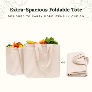 May include: Two off-white canvas tote bags, one filled with fresh produce including peppers and greens, and one folded flat. The text reads Extra-Spacious Foldable Tote, DESIGNED TO CARRY MORE ITEMS IN ONE GO. The bags feature two sturdy handles.