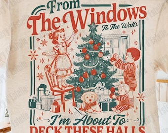 Könnte beinhalten: Cremefarbenes T-Shirt mit einem festlichen Weihnachtsgrafik. Das Design zeigt Kinder, die einen Weihnachtsbaum schmücken, einen Hund und den Text "From The Windows To The Walls, I'm About To Deck These Halls."