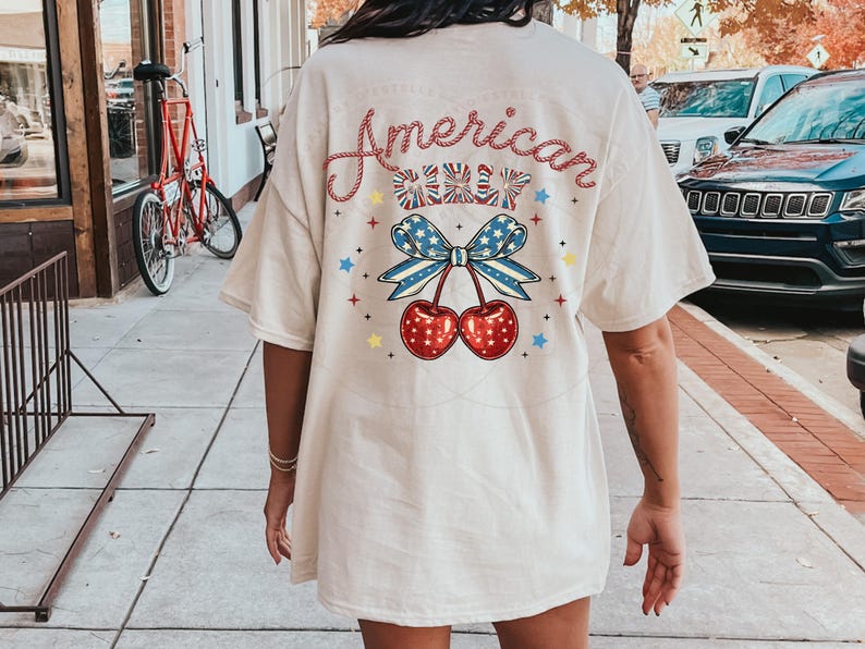 May include: A white t-shirt with a red, white and blue cherry design and the text "American Cherry" on the back.