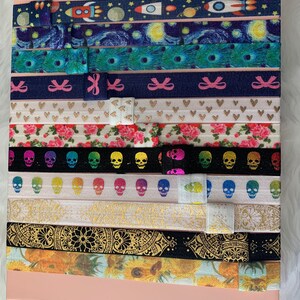 May include: A set of 12 colorful hair ties with various patterns, including a starry night sky, skulls, flowers, and geometric designs.